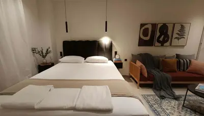 a bedroom with a large bed and a couch at The Victoria Suite Chic & Modern Studio Stay in Athens