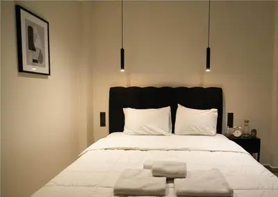 a bedroom with a large bed with a black headboard at The Victoria Suite Chic & Modern Studio Stay in Athens