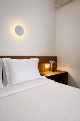 a bedroom with a white bed and a desk with a lamp at Atla Living Athens in Athens