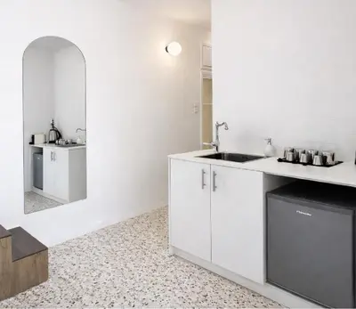 a white kitchen with a sink and a mirror at Atla Living Athens in Athens