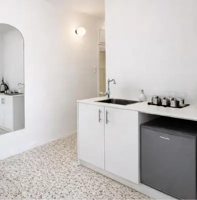 a white kitchen with a sink and a mirror at Atla Living Athens in Athens