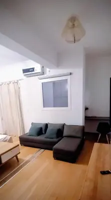 a living room with a black couch in a room at Cosy apartment close to the railway & metro stations in Athens
