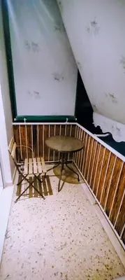 a table and chairs in a room with a wall at Cosy apartment close to the railway & metro stations in Athens