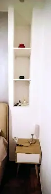 a white shelf in a room with a table at Cosy apartment close to the railway & metro stations in Athens