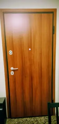 a wooden door with a handle on a wall at Cosy apartment close to the railway & metro stations in Athens