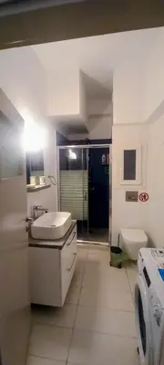 a bathroom with a sink and a washing machine at Cosy apartment close to the railway & metro stations in Athens