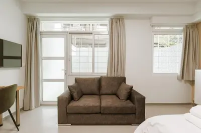 a living room with a couch in front of a window at Charming 1BR Studio in the Heart of Athens in Athens