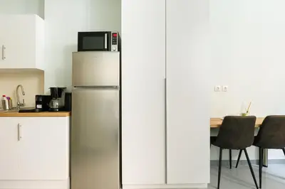 a kitchen with a refrigerator with a microwave on top at Charming 1BR Studio in the Heart of Athens in Athens