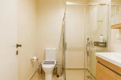 a bathroom with a toilet and a glass shower at Charming 1BR Studio in the Heart of Athens in Athens