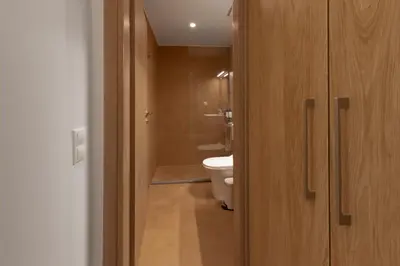 a bathroom with a toilet and a wooden door at AthenianNest Asomaton Boutique Studio in Psyrri near Acropolis in Athens