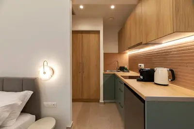 a kitchen with wooden cabinets and a counter top at AthenianNest Asomaton Boutique Studio in Psyrri near Acropolis in Athens