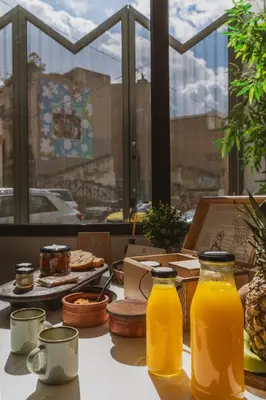 a table topped with lots of bottles of orange juice at AthenianNest Asomaton Boutique Studio in Psyrri near Acropolis in Athens