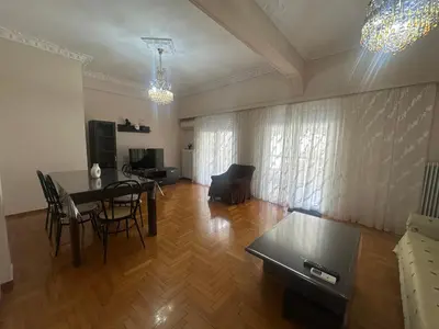 a living room with a table and chairs in a room at Kallisto Heart of Athens in Athens