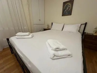 a bedroom with a white bed with towels on it at Kallisto Heart of Athens in Athens