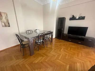 a dining room with a table and chairs and a television at Kallisto Heart of Athens in Athens