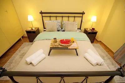 a bed with a table with a bowl of fruit on it at Retro Athens in Athens