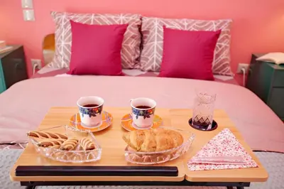 a tray with two cups of coffee and pastries on a bed at Retro Athens in Athens