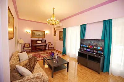 a living room with a couch and a flat screen tv at Retro Athens in Athens