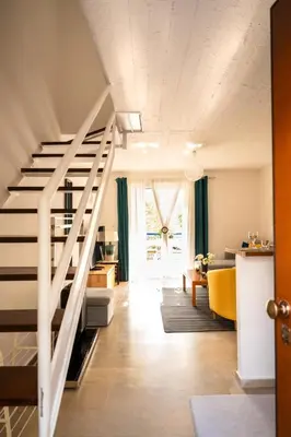 a living room with a staircase leading to a living room at 15 minutes from Athens airport in Porto Rafti