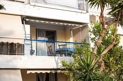 a balcony of a building with a blue railing at 15 minutes from Athens airport in Porto Rafti