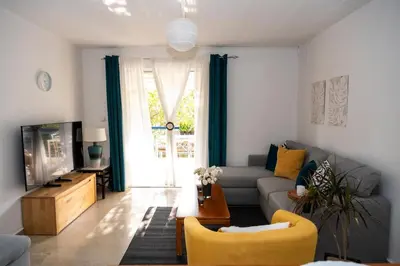 a living room with a couch and a tv at 15 minutes from Athens airport in Porto Rafti