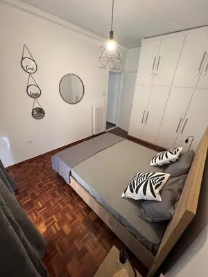 a bedroom with a bed and a mirror on the wall at Charming Apartment, Walk to Metro & Markets in Athens