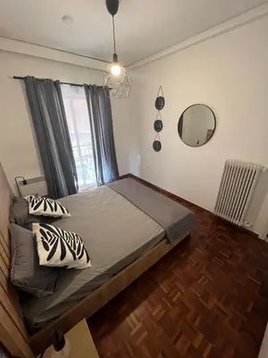 a bedroom with a bed with a window and a mirror at Charming Apartment, Walk to Metro & Markets in Athens