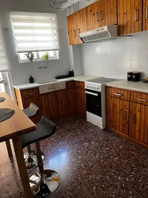 a kitchen with wooden cabinets and a stove top oven at Charming Apartment, Walk to Metro & Markets in Athens