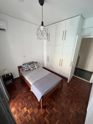 a bedroom with a bed and a white cabinet at Charming Apartment, Walk to Metro & Markets in Athens