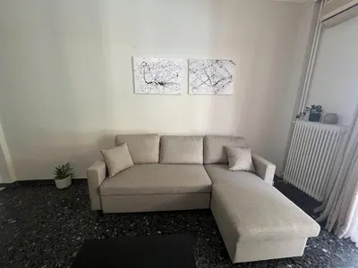 a living room with a couch and two paintings on the wall at Charming Apartment, Walk to Metro & Markets in Athens