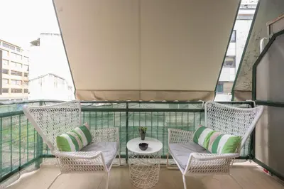 a balcony with wicker chairs and a table at Elegant Dimitra, Your Beautiful Home in Athens, by Acropolin in Athens