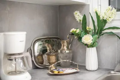 a kitchen counter with a vase of flowers and a sink at Elegant Dimitra, Your Beautiful Home in Athens, by Acropolin in Athens