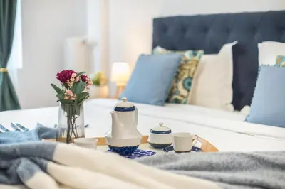 a table with cups and flowers on a bed at Elegant Dimitra, Your Beautiful Home in Athens, by Acropolin in Athens