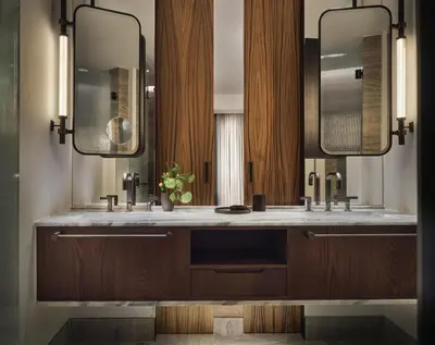 a bathroom with two sinks and two mirrors at Conrad Athens The Ilisian in Athens