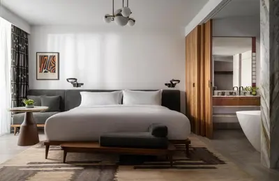 a bedroom with a large bed and a bath tub at Conrad Athens The Ilisian in Athens