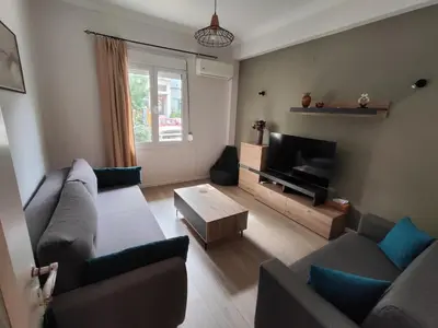 a living room with a couch and a tv at RG Living Spaces Neo Psychiko in Athens