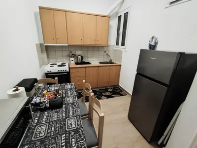 a kitchen with a table and a black refrigerator at RG Living Spaces Neo Psychiko in Athens