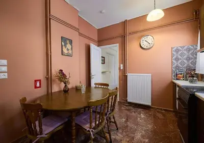 a dining room with a table and a clock on the wall at Kefallinias Classic in Athens