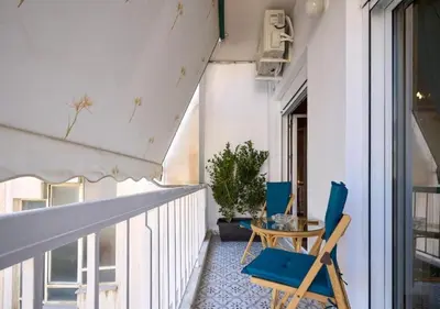 a balcony with two blue chairs and a table at Kefallinias Classic in Athens