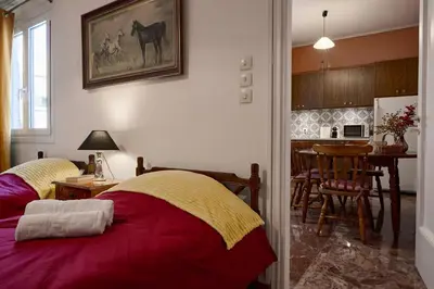 a bedroom with two beds and a kitchen with a table at Kefallinias Classic in Athens