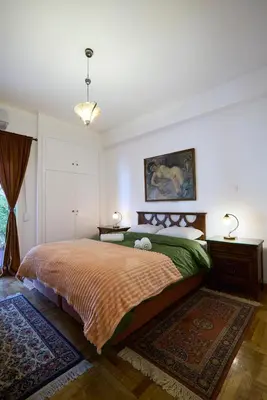 a bedroom with a large bed and a rug at Kefallinias Classic in Athens