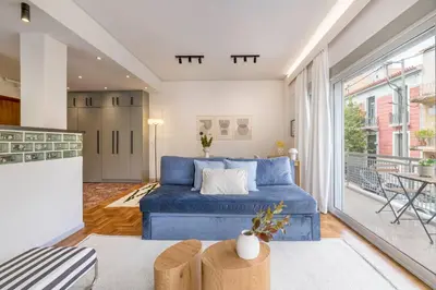 a living room with a blue couch and a large window at Calming 1BR Apartment with Acropolis view in Athens