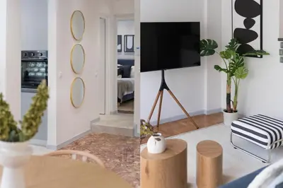 a living room with a tv and a room with a table at Calming 1BR Apartment with Acropolis view in Athens