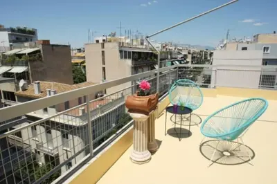a balcony with two chairs and a plant on a pole at Lovely Studio With Amazing Terrace in Athens