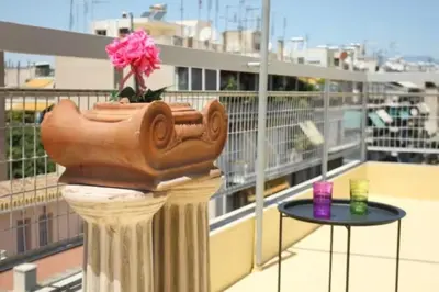 a vase on a column on a balcony with a table at Lovely Studio With Amazing Terrace in Athens