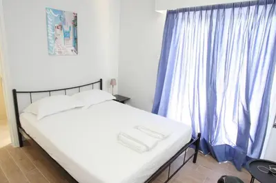 a bedroom with a bed with a blue curtain at Lovely Studio With Amazing Terrace in Athens