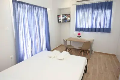 a room with two beds and a table and a desk at Lovely Studio With Amazing Terrace in Athens