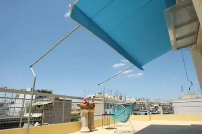 a balcony with a fire hydrant and chairs on a roof at Lovely Studio With Amazing Terrace in Athens