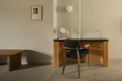 a black desk with a chair next to a table at P28 Suite 105 in Athens