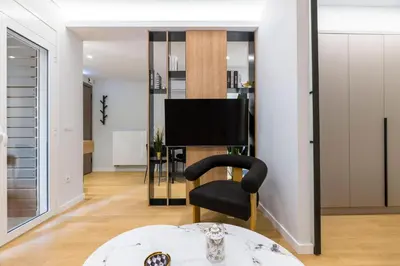 a living room with a black chair and a television at Voukourestiou Grand Residence 56 in Athens